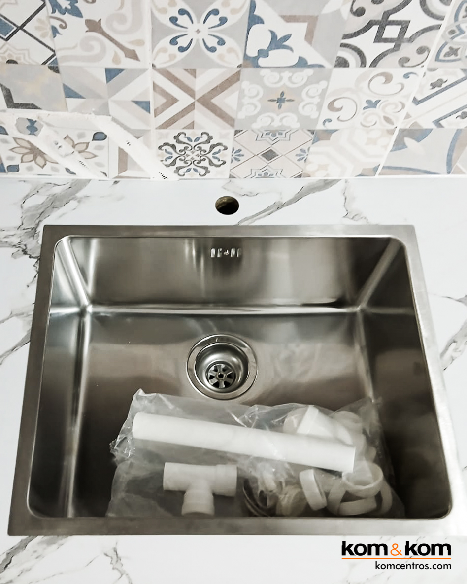 fregadero de borde extrafino sobre encimera laminada imitación mármol blanco.